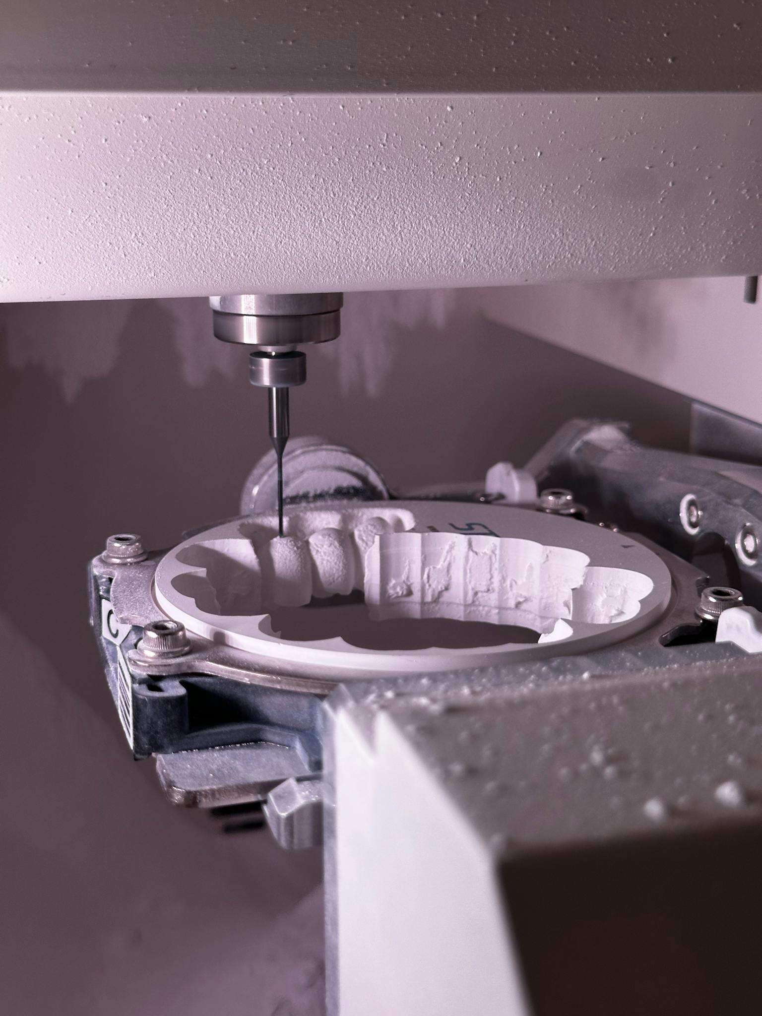 Detailed view of CNC grinding machine shaping ceramic material with precision tool.